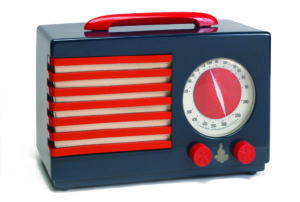 A rectangular radio sits against a white background. It is grayish blue with vibrant red details.
