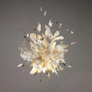 "Hanging lamp composed of shards of broken white porcelain dishes, cups, saucers, serving pieces, and stainless steel cutlery, mounted on a metal frame work radiating from a central light source; the overall effect evoking an explosion of tableware.