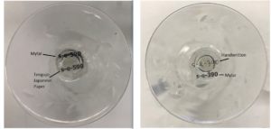 A composite image of two photographs. Both depict the underside of a wine glass, each with accession numbers handwritten and printed and adhered to the glass.