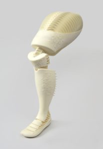 Image features a white nylon prosthetic leg spanning mid-thigh to foot; hollow form, jointed to bend at knee and foot. Please scroll down to read the blog post about this object.