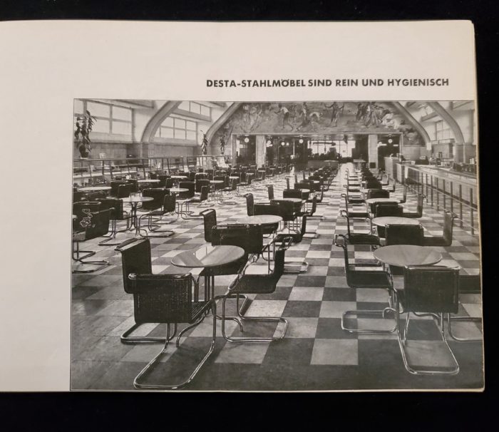 Image features Cafeteria Interior with tubular tables and chairs “Desta-Stahlmobel sind rein und hygienisch” (Desta Stahlmobel is pure and hygienic)