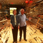 Barbara and Mort in the galleries, where a giant installation showing tools and technologies floats around their heads