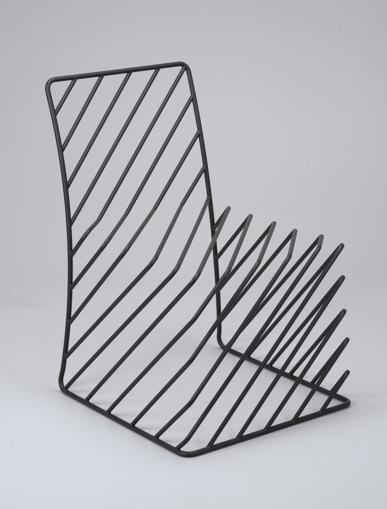 Image features a side chair composed of black tubular steel rods, some diagonally set, bent to form the chair's outline and volume. Please scroll down to read the blog about this object.