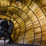 Visitors are inside a giant cavern constructed from green-brown seaweed