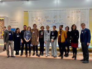 The Smithsonian team and designers smile in front of the Partnering with Nature exhibition