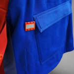 Square blue coat pocket with small rectangular tabs on the inside of the jacket