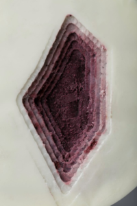 Diamond-shaped purple hole in a white surface