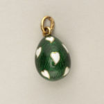 Egg-shaped, enameled with white hearts on dark green background.