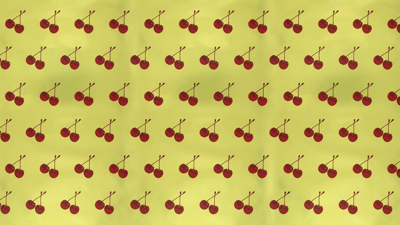 A repeating patter of two shiny cherries with stems intertwined on a shiny gold background