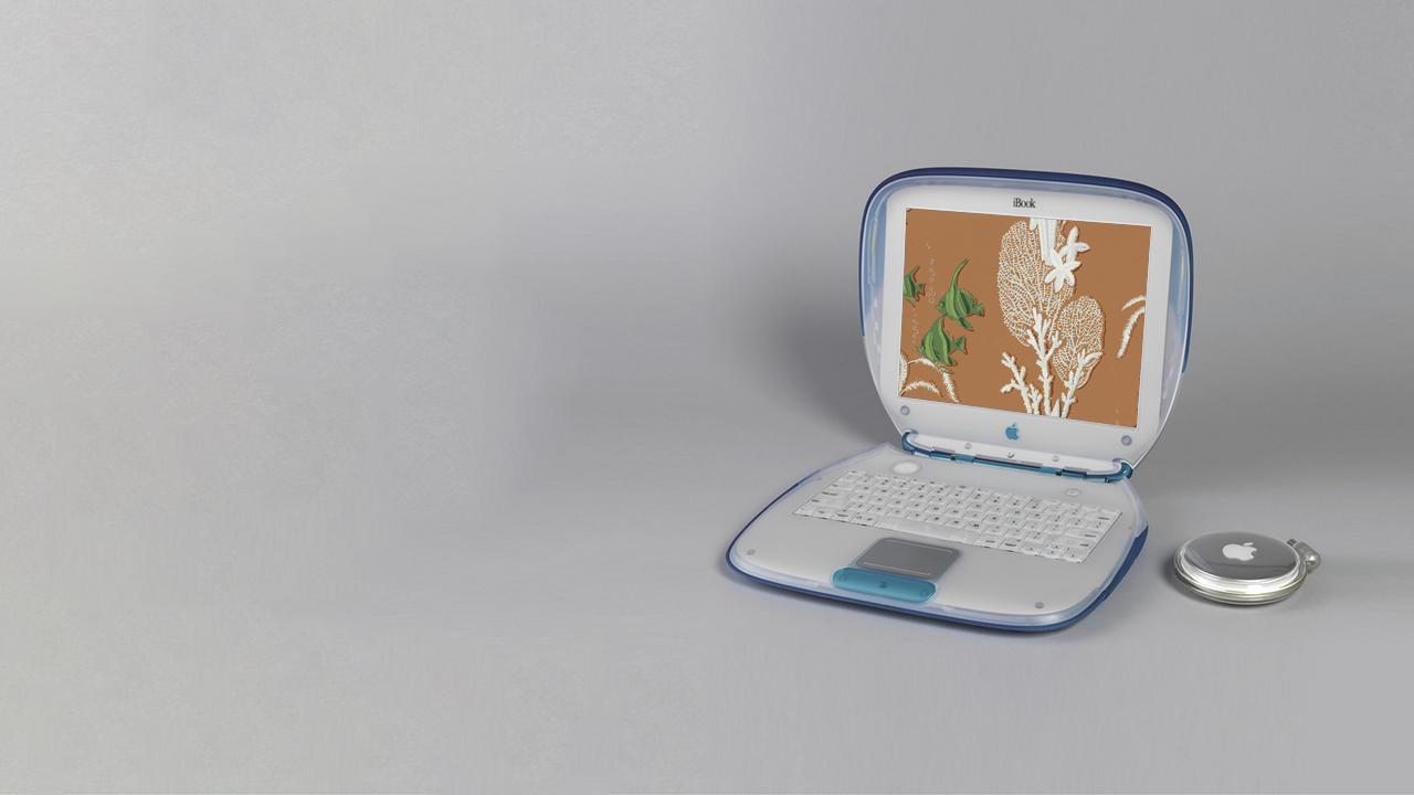 An old school Mac laptop with a semi-translucent blue case. Digitally, the screen of the laptop has been replaced with an orange wallpaper with green tropical fish and white coral swimming on an orange background.