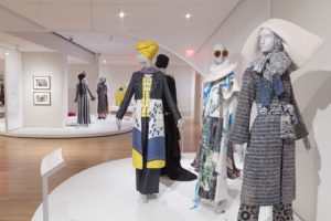 A view of the galleries at Cooper Hewitt showcasing Contemporary Muslim Fashions. Several garments are displayed on mannequins.