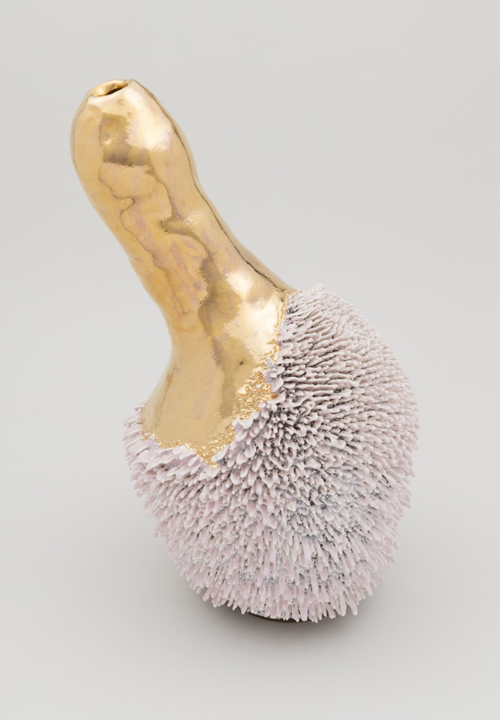 Image features a ceramic vase with a slender neck and bulbous base. The neck is smooth and gilded. The base has a prickly, fur-like texture and is light pink. Please scroll down to read the blog post about this object.