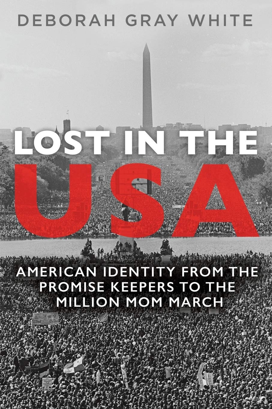 Book cover of Lost in the Usa: American Identity from the promise keepers to the million mom march by Deborah Gray White. It is illustrated with a black and white photo of thousands, perhaps tens of thousands, of people gathered in front of the Washington Monument in Washington, D.C.