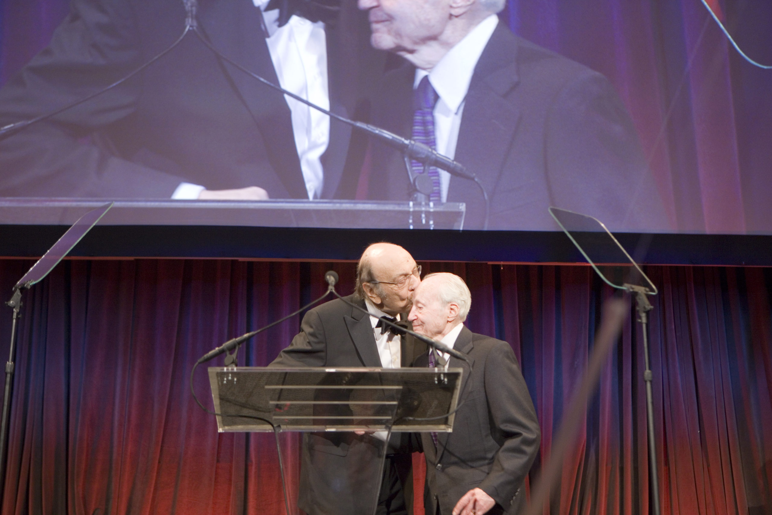 On stage at the National Design Awards gala, a man in a suit tenderly kisses Ralph Caplan on the head