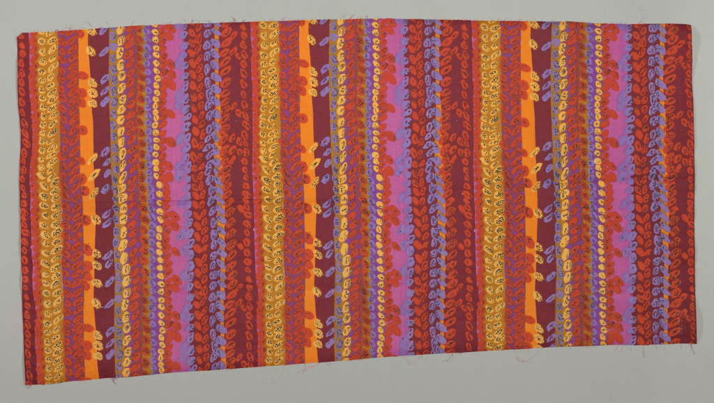 Image features: Printed length in a design of uneven vertical stripes with overlapping small oval leaf or bead shapes in strong reds, orange, blue, mauve and yellow. Please scroll down to read the blog post about this image.