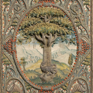 Detailed embroidery of a tree in a patterned frame