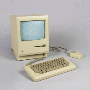A gif of falling snowflakes on a light blue ground plays on the screen of a still, beige rectangular computer with a floppy disc drive and a rainbow stripe Apple Inc. logo, connected to a plastic keyboard and mouse with wires.