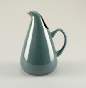 Green-blue teardrop-like pitcher with graceful tulip-leaf spout that curves into a handle low on it's body.