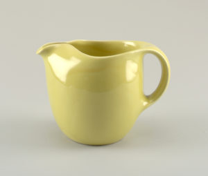 Stout yellow pitcher with subtle spout opposite a curved handle. Has a broad mouth at top.