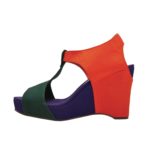 A wedge sandal photographed in profile with a dark purple bottom, and red and green straps.