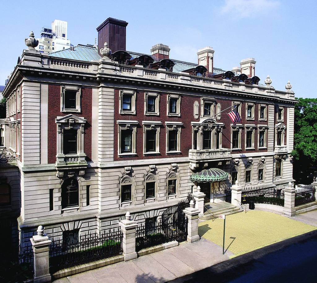 Photograph of a four-story mansion on a quiet city street.