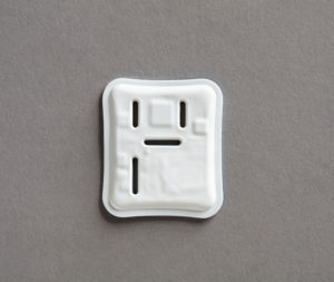 A rubbery white square with rounded edges, raised squares, and thin black openings