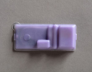 Purple rectangular sensory in rubbery material with raised ridges and a rectangular protrusion at its center