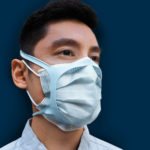 A man wearing a surgical mask and a silicone brace layered over it.