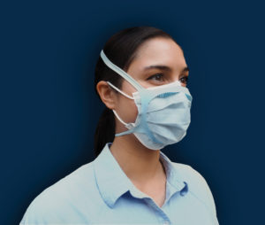 A woman wearing a surgical mask and a silicone brace layered over it.