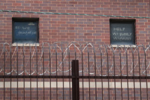 Exterior of brick jail with desperate messages written on windows