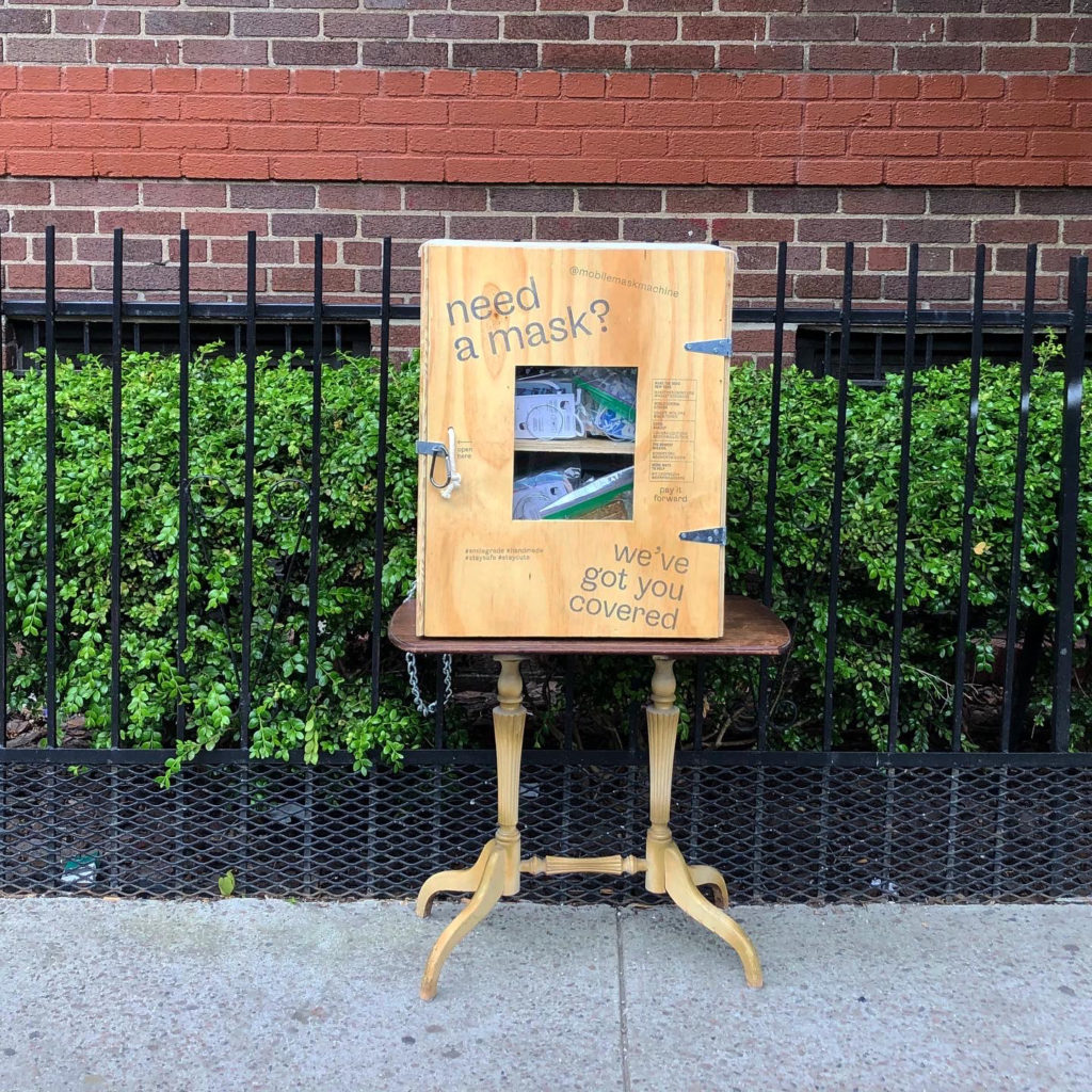 Plywood box with masks inside placed outside on side table