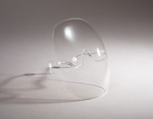 Clear, oval-shaped face shield with rounded edges, a curved nose bridge, and eyeglass arms to secure behind a user's ears.