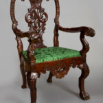 Elaborately carved mahogany or primavera chair inspired by Chippendale design; the upholstery is modern.