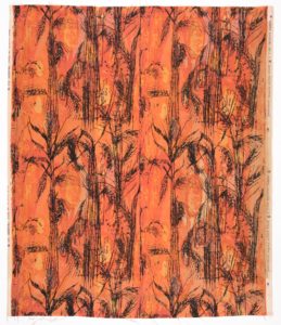 Printed fabric has a design of wheat sheaves in black against a background of orange and yellow.
