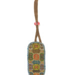 Small, rounded rectangular beige case with a multi-colored floral pattern on the front and blue tent-stitching around the edges, a loop of brown suede-like string extends from the top held together with a pink bead