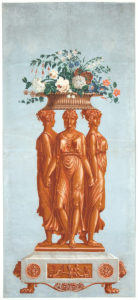Print of three bronze classical female figures dressed in long ruffled robes standing holding hands back-to-back on a white marble plinth supporting a large bouquet of colorful flowers on their heads