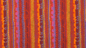 Vertical columns of vibrant reds, oranges, pinks, and purples cover a long, horizontal textile, with equally vibrant columns of leaf-like ovals overlaid on most of the fabric.