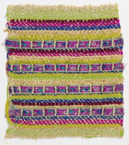 Horizontal woven rows made of different materials of different thicknesses and vibrant colors form a heavily textured, mixed media fabric.