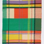 Brightly colored textile with a blocky plaid-like pattern in green, yellow, red, and purple.