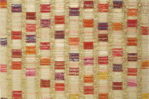 Vertical columns of light golden thread run down the length of a long textile, with vibrant squares of pink, purple, red, and yellow cascading down the columns.