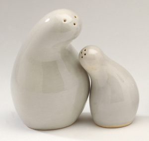 Two white ceramic salt shakers with rounded bodies that curve into each other, evoking a mother and child leaning into each other for an embrace.