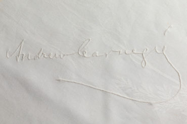 Andrew Carnegie's signature embroidered on a white tablecloth.