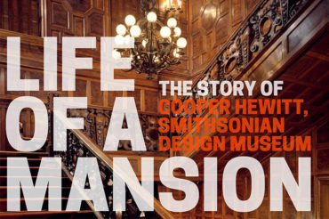 Dark wood paneled staircase with large chandelier and extremely large bold type saying "LIFE OF A MANSION: THE STORY OF COOPER HEWITT, SMITHSONIAN DESIGN MUSEUM" in all capitals.