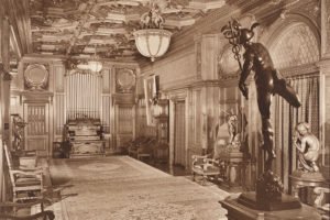 Historical photograph of a lavish interior with woodwork, lighting fixtures, and sculptures.