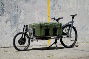 An extra-long bicycle with an olive green cargo box in the center.
