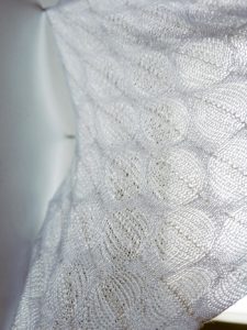 A close up photo of white knitted fabric.