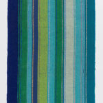 A long, thin rectangular woven fabric featuring vertical stripes of blues and greens with metallic accents.