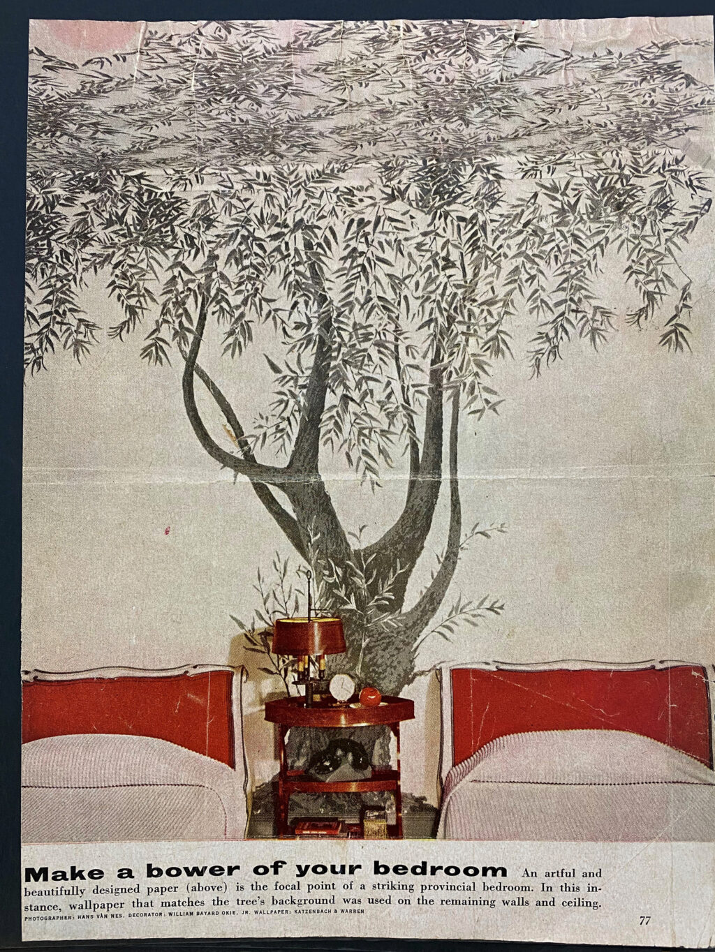 Page of a magazine picturing a bedroom with two twin beds and a wall decorated with a mural of a tree. The tagline 