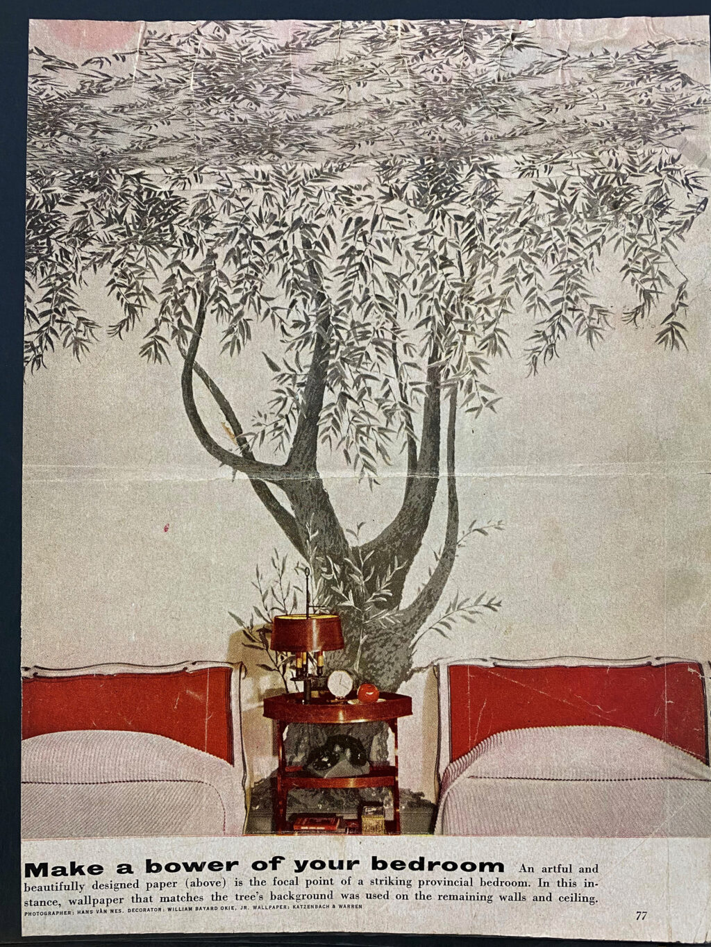 Page of a magazine picturing a bedroom with two twin beds and a wall decorated with a mural of a tree. The tagline