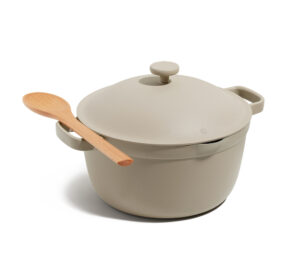 A grey pot with a lid and a wooden spoon resting on the left handle.